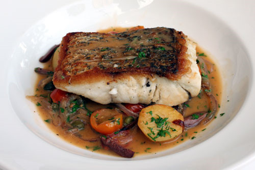 Sau đó thả cá đã nướng vào vào thoa bơ hai bên cho đều. Nêm gia vị lại cho thật vừa ăn thì múc ra. Sắp cải xà lách soong và khoai tây đã chiên vàng xung quanh đĩa. Đặt cá vào giữa. Ảnh: thanhnien.vn.