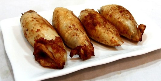 Cho mực vào khay đã bôi mỡ và có tỏi đập dập, tưới mỡ nước lên mực, đưa khay vào lò nướng <200 độ C>. Trước khi lấy mực ra, quết lên mực một lớp mạch nha hòa nước. Mực nướng chín vàng đều là được. Ảnh: kenh14.vn.