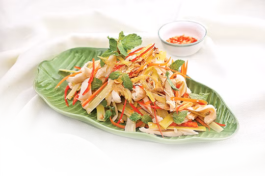 Củ sen gọt vỏ, xắt mỏng 0,3cm ngâm giống ngó sen. Kiệu, rau răm xắt nhuyễn. Trộn chung tôm, thịt đùi, tai heo, hành tây, ngó sen, củ sen, rau răm, kiệu, muối, đường, bột ngọt, nước chanh, nước mắm, tỏi phi. Trộn lại đều, nêm gia vị chua chua ngọt ngọt là được. Ảnh: cachlammonngon.com.