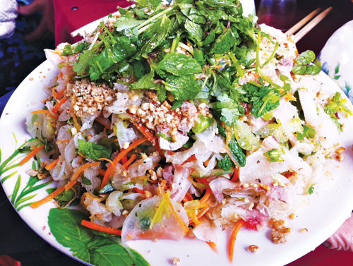 Cho củ cải đã vắt ráo vào thau sạch, sau đó cho cà rốt, khế, thịt, tôm vào trộn cùng với nước mắm ớt chua ngọt được pha khéo léo. Khi gia vị đã hòa cùng các nguyên liệu, thì cho chút dầu phụng phi hành, rau thơm, đậu phụng vào, trộn đều lên. Ảnh: thanhnien.vn.