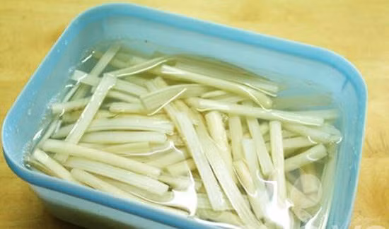 Tôm cho lên chảo rang khô với chút muối, khi chín bóc vỏ chừa đuôi. Thịt đùi và tai heo: luộc chín, xắt vừa ăn. Hành tím: phi vàng. Hành tây bào mỏng ngâm giấm đường. Ngó sen: cắt ngắn, chẻ làm hai, ngâm nước lạnh pha phèn chua 10 phút xong xả sạch, ướp một muỗng súp đường, vẩy ráo. Ảnh: 2monanmoingay.net.