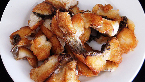 Bắc chảo dầu lên bếp, chờ dầu nóng thì cho từng miếng cá vào, vặn xuống mức lửa vừa. Chiên đến khi cá vàng giòn 2 mặt thì vớt ra giấy có lót giấy thấm dầu để lượng dầu ăn được trôi bớt. Ảnh: aFamily.vn.