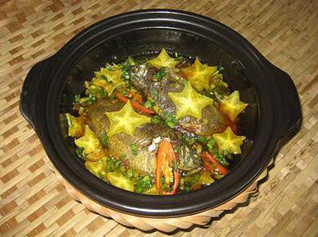 Cho củ gừng xắt sợi vào. Nêm thêm nước mắm, đường, ớt bột, ớt. Bật lửa lên kho, cho thêm nước sôi ngập cá kho đến khi nước sệt lại. Nêm nếm lại rồi cho lá gừng vào và tắt bếp. Ảnh: cakholangvudai.com.