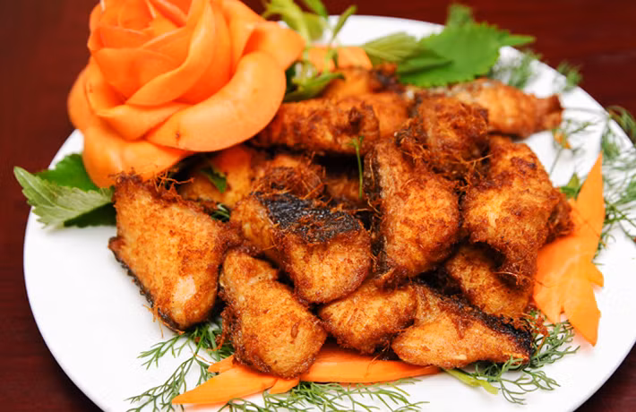 Cá đã chiên xong ta phết sốt rồi đem nướng. Nướng từ từ để cá lên màu, khi cá có mùi thơm bề mặt vàng cánh rán miếng cá khô mặt, có hương thơm là xong. Nước chấm pha tỉ lệ: hương nấm 2 chai, dầu hào 1 chai, mù tạt 10 tuýp. Ảnh: tanque.vn.