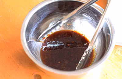 Làm sốt: Cho tương ớt, đường nâu, nước tương, nước, gừng, tỏi băm nhỏ, giấm gạo, nước cốt chanh và ít ớt bột vào nồi, để đun dưới lửa vừa, đến khi thấy nước trong nồi sệt lại thì tắt bếp. Ảnh: aFamily.vn.