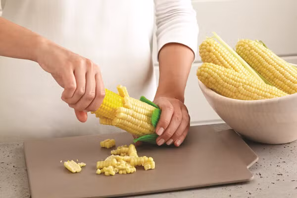 4. Salad ngô giòn cay. Nguyên liệu: Ngô ngọt, dầu oliu, muối, tiêu, ớt bột, phô mai, hành tây, ớt chuông, chanh, rau ngò, giấy bạc. Ngô ngọt để ráo nước. Sau đó cho ngô vào tô và thêm muối + tiêu + dầu oliu và trộn đều. Ảnh: Monngon.tv.