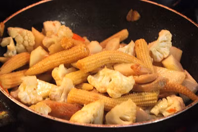 Cà rốt, su hào gọt vỏ, rửa sạch, cắt khúc ngắn vừa ăn. Súp lơ trắng rửa sạch, cắt nhỏ. Ngô bao tử, hành lá, rửa sạch. Ảnh: congthucmonngon.com.