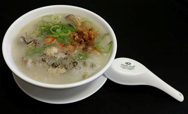 Cháo chín múc ra nồi nhỏ, đổ nước hàu vào đun cùng, nêm chút mắm ngon, cùng thịt hàu vừa xào, đảo đều, đun khoảng 3 phút. Thêm ít hành răm thái nhỏ cùng chút mì chính vào nồi cháo, xúc cháo ra bát tô dùng nóng. Nhớ thêm ít ớt khô hoặc hạt tiêu ăn kèm. Ảnh: Foody.vn.