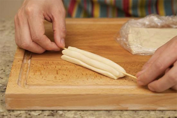 Trộn bột với nước. Nhào kỹ khối bột rồi ủ khối bột khoảng 15 phút . Nhào lại một lần. Lặp lai bước trên 2 lần. Cán khối bột ra thành miếng dày 2 cm rộng 5 cm. Bọc khối bột lại bằng giấy nilon có tráng một ít dầu ăn cho khỏi dính. Ủ khoảng 3 đến 5 giờ. Ảnh: momkitty.com.