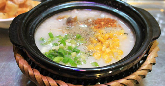 Luộc ngô bằng nước hầm sườn. Gan heo rửa sạch với muối, xào chín, thêm nước tương, tương cà cho đậm đà. Đun nước hầm xương rồi bỏ cháo ăn liền vào cho đến khi cháo chín, bỏ ngô và sườn vào, nêm gia vị vừa ăn. Ảnh: pasgo.vn.