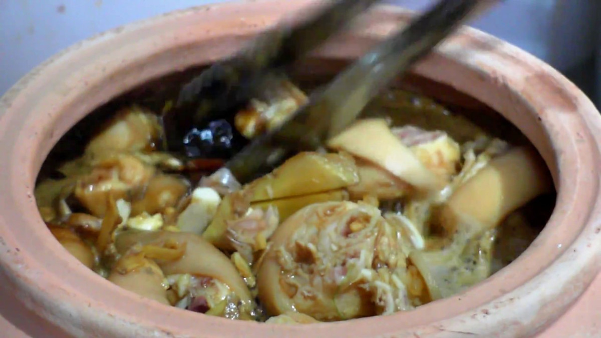 Cho dầu màu điều vào chảo phi với tỏi. Tỏi vừa dậy mùi thì trút thịt vào đảo tới đảo lui cho săn lại. Chẻ mía thành từng thanh dọc, xếp mía vào đáy một chiếc nồi sạch. Cho bắp giò đã xào vào nồi, đổ nước dừa vừa ngập mặt thịt. Đậy nắp hầm cho thịt mềm. Ảnh: youtube.com.