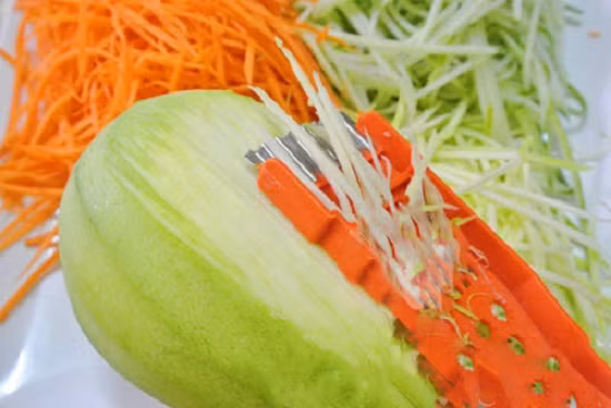 Xoài rửa sạch, gọt vỏ, cắt thành những sợi xoài dài. Rau húng cắt nhỏ. Tỏi ớt băm nhỏ. Tôm thái lát, giò thái lát dài trụng sơ qua nước sôi. Ảnh: toinayangi.vn.