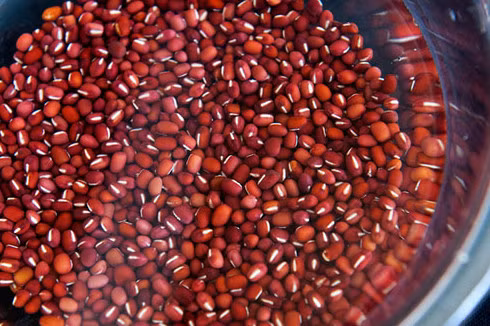 2. Thạch đậu đỏ. Nguyên liệu: Đậu đỏ, đường trắng, nước lọc, muối, vani, gelatin, hạt dẻ. Đậu đỏ rửa sạch, cho vào nồi với 6 cup nước rồi đun sôi trên lửa vừa khoảng 30 phút. Để yên thêm 30 phút cho đậu mềm nhừ. Tiếp tục nấu thêm 1 giờ nữa. Đánh nát đậu bằng thìa gỗ. Ảnh: blogtrangda.com.