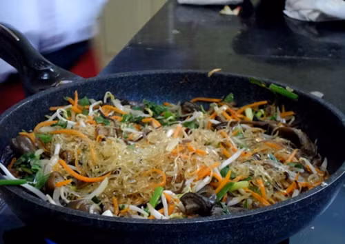 Cho chút dầu vào, đun cho dầu nóng già rồi thả hành băm nhỏ vào phi thơm. Sau đó bạn trút hết lòng, mề gà vào xào cho chín, cho tiếp mộc nhĩ, nấm hương vào xào cùng. Đảo đều tay đến khi lòng gà chín thì cho miến vào đảo cùng trên lửa thật to. Ảnh: Lamsao.com.