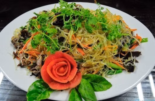 Sau khi đảo qua vài lần, bạn cho cà rốt thái sợi vào rồi đảo thật nhanh. Cuối cùng đến khi miến, lòng gà đã chín hẳn, bạn cho giá đỗ, hành hoa, rau răm đã thái nhỏ vào đảo đều tay một lần nữa, nêm nếm thêm gia vị cho vừa miệng là xong. Ảnh: GiaDinh.TV.