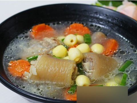 Cà rốt nạo vỏ rồi tỉa hình bông hoa, hành lá thái khúc. Khi đuôi heo đã gần chín mềm thì cho hạt sen và cà rốt vào, hầm tiếp để 2 nguyên liệu chín, thêm chút nước mắm, nếm lại vừa ăn rồi cho hành lá vào là tắt bếp. Ảnh: kienthuccuocsong.info.