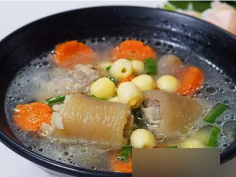 Cà rốt nạo vỏ rồi tỉa hình bông hoa, hành lá thái khúc. Khi đuôi heo đã gần chín mềm thì cho hạt sen và cà rốt vào, hầm tiếp để 2 nguyên liệu chín, thêm chút nước mắm, nếm lại vừa ăn rồi cho hành lá vào là tắt bếp. Ảnh: kienthuccuocsong.info.