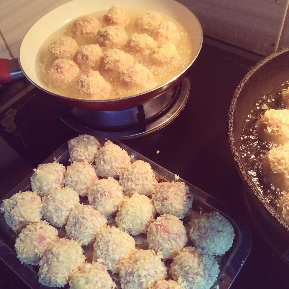 Chuẩn bị một đĩa bột mì, một đĩa bột chiên giòn, một đĩa lòng đỏ trứng đánh tan, một đĩa bột chiên xù. Đầu tiên lấy trứng gà luộc lăn qua đĩa bột mì, lấy thịt với khoai đã trộn bọc lấy trứng đã phủ bột mì thật kín rồi nặn miếng thịt khoai thật tròn. Ảnh: monanngon.org.