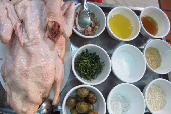 3. Vịt om sấu nước dừa. Nguyên liệu: Thịt vịt, nước dừa, sấu, sả, gừng, gia vị, rau ngổ. Rắc muối lên miếng thịt vịt sau đó chà xát kĩ rồi rửa sạch với nước. Chặt thịt vịt thành những miếng vừa ăn. Sả đập dập phần đầu sả rồi băm nhỏ. Gừng gọt vỏ băm nhỏ. Ảnh: vaobeocungban.org.