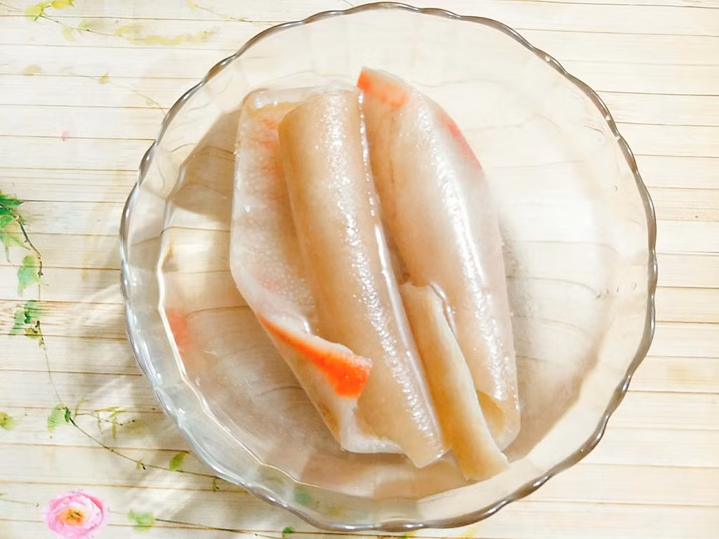 2. Bì lợn xóc muối ớt. Nguyên liệu: Bì lợn, dấm, muối, đường, bột canh, ớt bột. Bì lợn cạo sạch lông, lọc sạch mỡ. Rửa sạch cho vào nồi luộc, nêm vào nồi 3 muỗng dấm để da bớt hôi, 1 thìa muối, nước sôi tầm 4 đến 5 phút vớt bì lợn để vào tô nước lạnh cho da nguội. Ảnh: zing.vn.