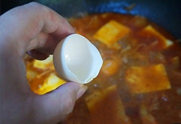 Sau khi trộn hỗn hợp xong, làm nóng một nồi đất sét trên bếp với lửa lớn khoảng 3-4 phút. Cho thêm dầu ăn, hành tây, tỏi vào. Đảo đều trong 1 phút cho thơm thì cho thịt lợn vào, đảo trong 3 phút cho đến khi thịt không còn màu hồng và có vỏ ngoài đẹp mắt. Ảnh: Wikibanh.com.