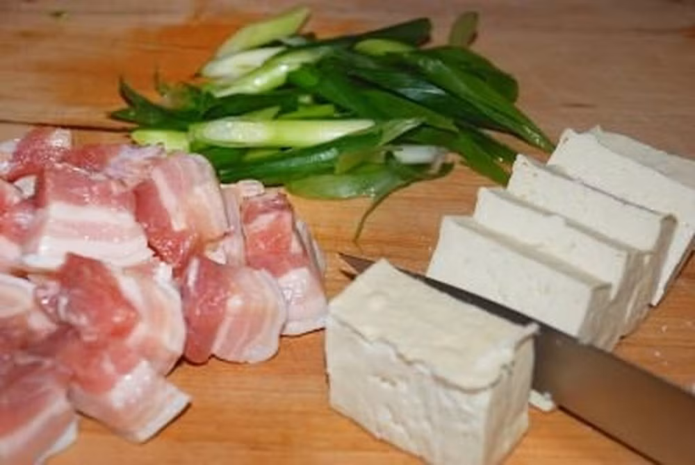 1. Canh kim chi thịt heo. Nguyên liệu: Cá cơm, củ cải, tảo khô, bột ớt, dầu mè, dầu thực vật, thịt ba chỉ, hành tây, tỏi, hành lá, kim chi, muối, đường, đậu hũ non, trứng. Sơ chế các nguyên liệu cho thật ngon, đẹp mắt.