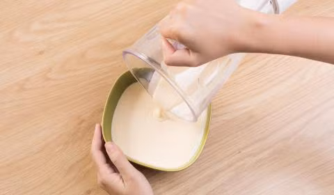 Cà chua cắt làm đôi, cho vào khay, đổ dầu oliu vào và nướng ở 150 độ C khoảng 20 phút. Tán mịn phô mai. Ảnh: conbocuoi.com.vn.