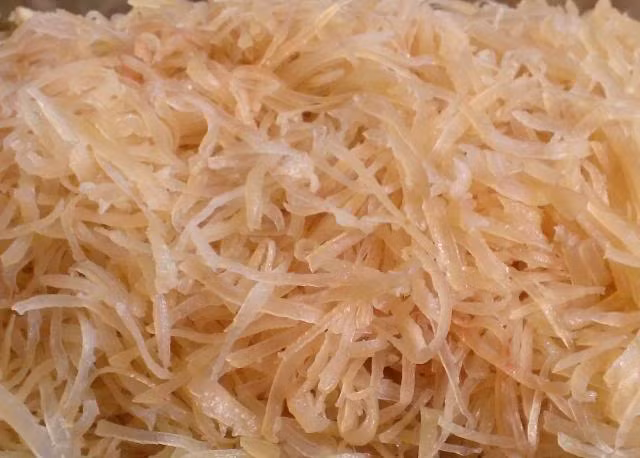 Thính được làm từ gạo ngâm trong nước qua một đêm rồi để ráo nước. Rang gạo vàng trên chảo rồi xay thành bột làm thành thính sao cho thính có màu ngà ngà, thơm phức. Bì lợn thái chỉ mỏng như sợi miến. Ảnh: MomKitty.com.