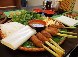 Phần sả còn lại đập dập cắt khúc khoảng ngón tay rồi tước đôi. Sau đó nặn phần thịt ở trên quanh cọng sả và rán vàng. Gắp nem lụi ra đĩa, ăn kèm bún, rau sống khi còn nóng. Ảnh: adacsan.com.