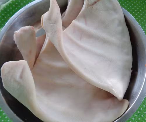 1. Nem tai trộn thính. Nguyên liệu: Tai lợn, thính, tỏi, ớt, chanh, rau ăn kèm (lá sung, lá đinh lăng, rau húng quế), gia vị (đường, nước mắm, muối, mì chính, giấm). Ảnh: NiemDamMe.com.vn.