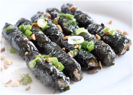 Sau đó múc ốc gói vào lá lốt, lấy tăm định hình cho khỏi rớt. Bắc chảo lên bếp cho chút xíu dầu ăn rồi đặt gói ốc vào chiên lửa vừa đến nhỏ chờ mặt dưới héo rút tăm lật lại ráo là xong rồi. Ảnh: 7monngonmoingay.info.