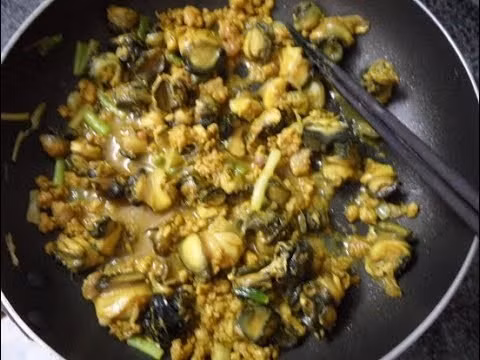 Thịt lợn thái mỏng, xào vàng cạnh rồi cho vào nồi ốc. Thịt đã xào vàng cho vào đun cùng ốc. Thêm một chút bột canh đun nhỏ lửa. Chuối xanh bóc lớp vỏ ngoài, ngâm nước cho không thâm. Thái vát mỏng tầm 0,5 cm. Hành tỏi bóc vỏ đập dập, phi vàng thơm rồi cho chuối vào xào. Ảnh: congthucmonngon.com.