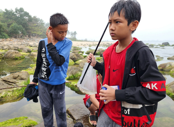Các em nhỏ cũng rủ nhau ra bãi rạn Nam Ô câu cá, bắt ốc. Ảnh: MINH TRƯỜNG. 