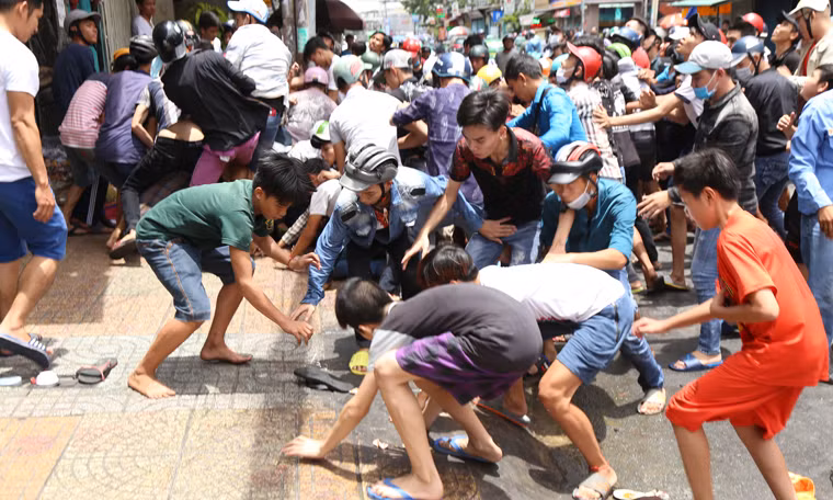 Đến 11h30 số lượng thanh niên đi giật tiền cúng cô hồn càng tăng lên và 30 phút tiếp theo thì chật kín cả con đường, giao thông ùn ứ. Để đảm bảo an ninh, công an phường và dân phòng đã có mặt từ sớm kiểm soát tình hình và điều tiết giao thông.