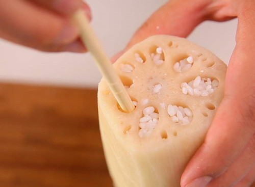 Dùng đũa nhồi gạo nếp vào các lỗ củ sen.