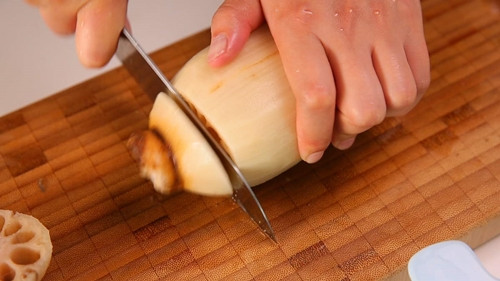 Cắt một đầu củ sen, ta sẽ nhồi gạo nếp vào các lỗ củ sen.