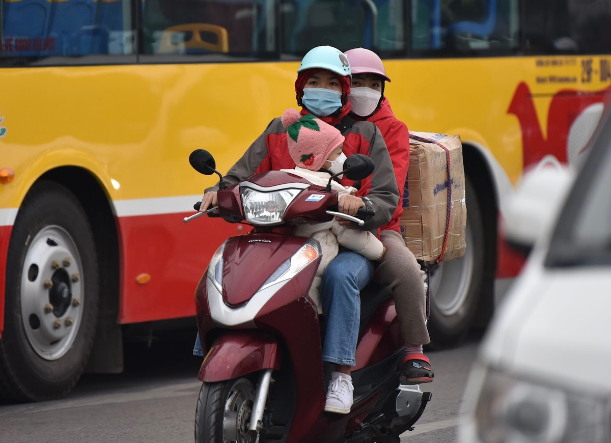 Thời tiết lạnh nên các em nhỏ được “nai nịt” rất kỹ khi đi xe máy.