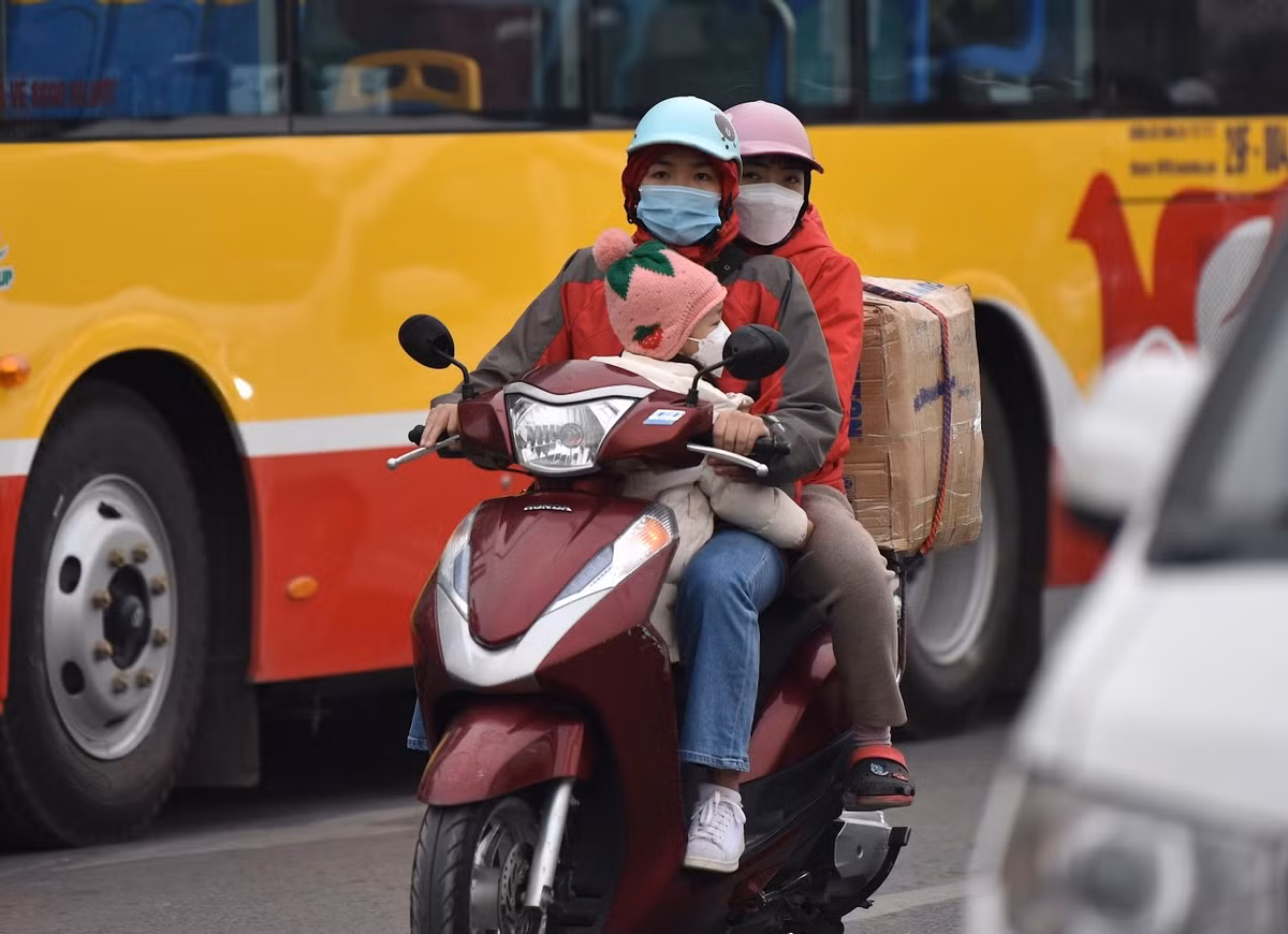 Thời tiết lạnh nên các em nhỏ được “nai nịt” rất kỹ khi đi xe máy.