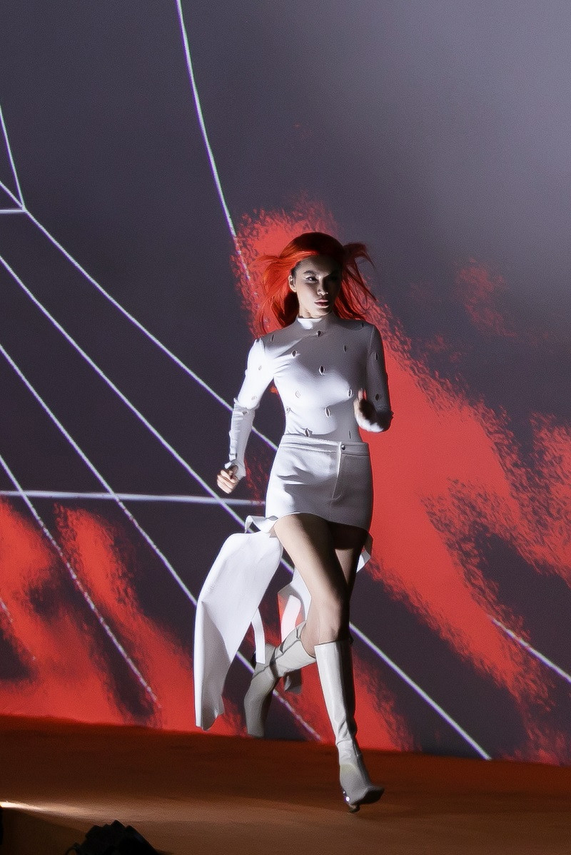 Với làn da nâu và mái tóc cam, siêu mẫu Minh Tú trở thành tâm điểm của sự chú ý trong mẫu thiết kế form ôm có chi tiết cut - out dứt khoát, tôn lên dáng hình và sức mạnh nội tại của người phụ nữ.