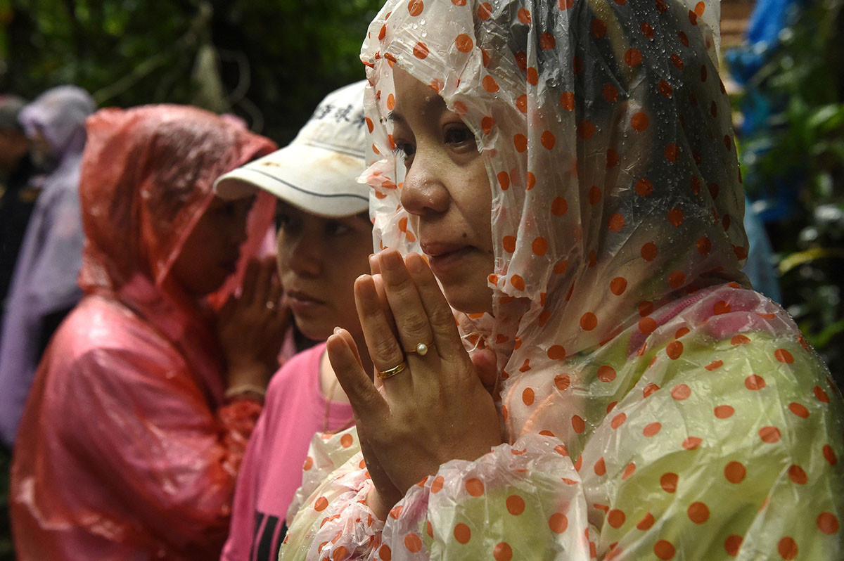 Gia đình của các thành viên trong đội bóng "Lợn Hoang" cầu nguyện bên ngoài hang Tham Luang. Nguồn ảnh: TA.