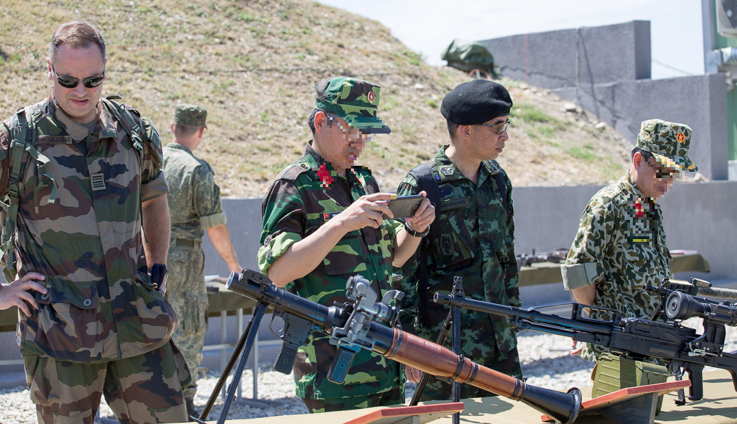 Trong đó có cả các quan sát viên và tùy viên quân sự của Quân đội Nhân dân Việt Nam. Có thể dễ dàng nhận thấy trong ảnh là hai quân nhân của Quân đội Nhân dân Việt Nam trong bộ quân phục quân trang dã chiến K07 quen thuộc. Nguồn ảnh: Milru.
