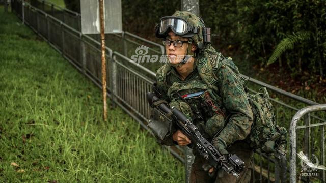 Cận cảnh một lính Singapore với đầy đủ trang bị trên người bao gồm mũ bảo hiểm, ba lô quân trang, bao đựng đạn kiêm áo giáp trước ngực, súng trường tấn công SAR-21. Nguồn ảnh: Sina.