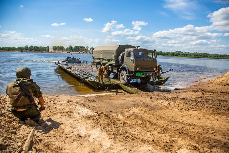 Các loại phương tiện hạng nặng có khả năng tự lội nước sẽ được đưa qua sông trước, nhằm tạp vành đai an toàn ở cả hai bên bờ sông trước khi cầu phao được tiến hành. Nguồn ảnh: Fotorepor.