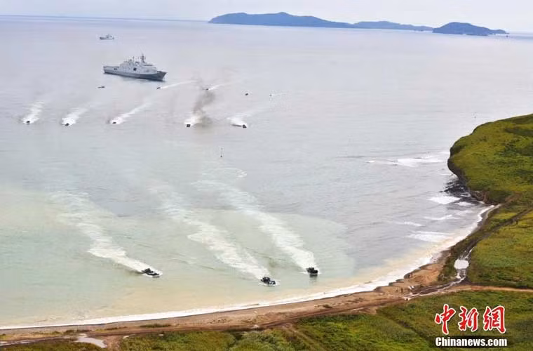 Ảnh các xe thiết giáp lội nước rời khỏi tàu đổ bộ lớn Type 071 tiến vào bãi đổ bộ.