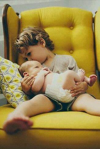 Anh bế em khi mẹ bận việc.