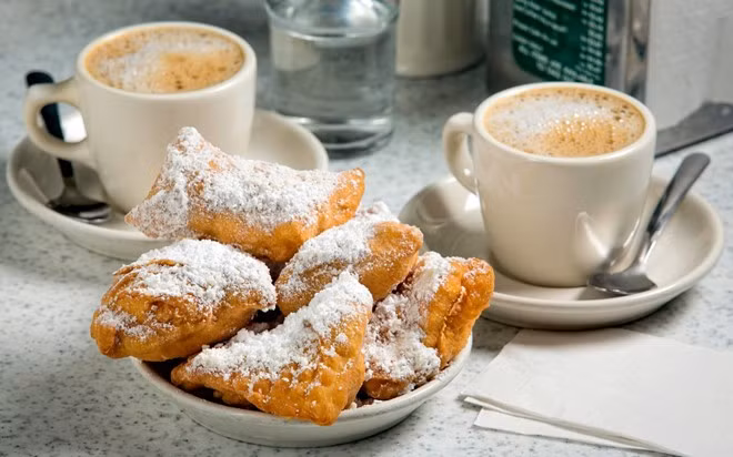 Bánh Beignets (New Orleans): Beignets là một loại bánh rán kiểu Pháp, bên trên có thêm lớp bột đường trắng tinh. Ảnh: Travelandleisure.