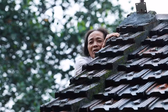 Bà Đặng Thị Hương (xã Phương Điền, Hương Khê) phải tạm trú trên mái nhà vì nước dâng cao, ngập hết các phòng. 