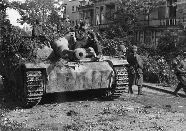 Một nhóm binh sĩ quân Đồng minh ngồi trên cỗ xe tăng.