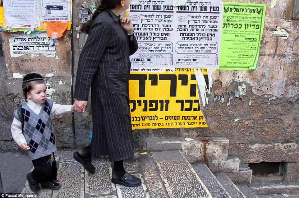 Người mẹ dắt con đi bộ qua một con phố ở Jerusalem, Israel năm 2010.