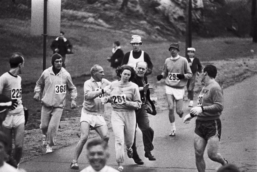 Bức ảnh chụp tại giải chạy Marathon Boston tổ chức năm 1967. Trong ảnh, một phụ nữ có tên Kathrine Switzer kiên trì chạy hết chặng hành trình bất kể thành viên ban tổ chức gây nhiều khó dễ nhằm mục đích khiến cô phải bỏ cuộc. Vào thời điểm ấy, sự bất bình đẳng giới vẫn còn tồn tại nặng nề trong đời sống xã hội Mỹ. Do vậy, giải chạy Marathon Boston cũng chỉ có nam giới được đăng ký tham gia.